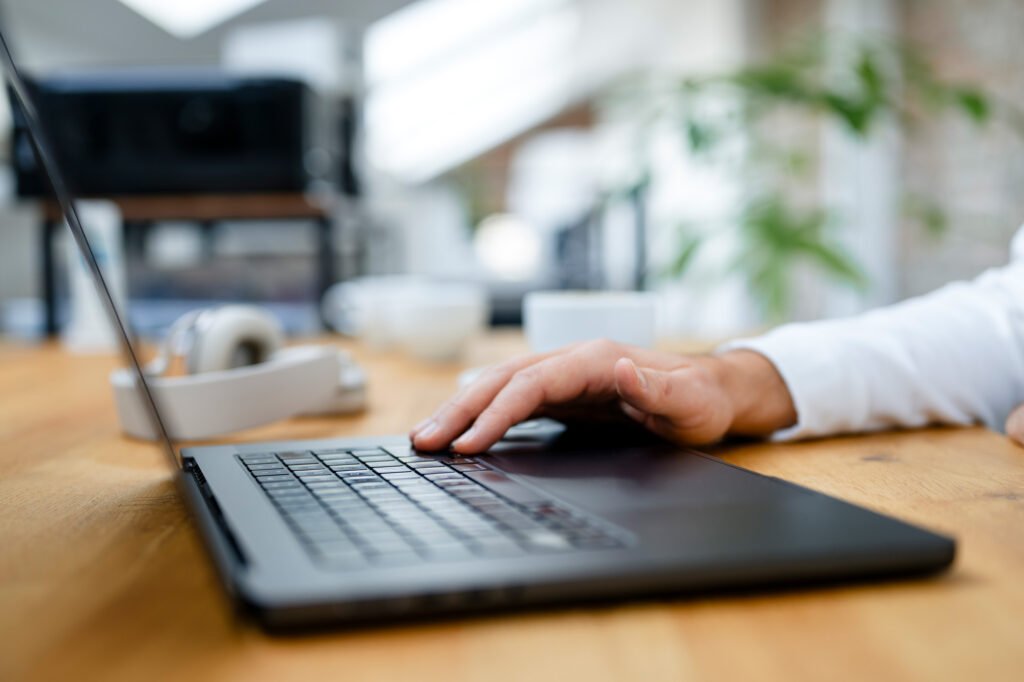 Person arbeitet konzentriert am Laptop in einem modernen Büro, als Beispiel für professionellen Webdesign-Prozess.