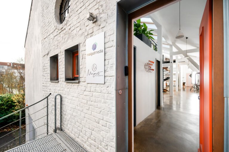 Eingang zu einem kreativen und modern gestalteten Büro der Maigut Media Agentur in Köln, mit offener Architektur und stilvoller Einrichtung.