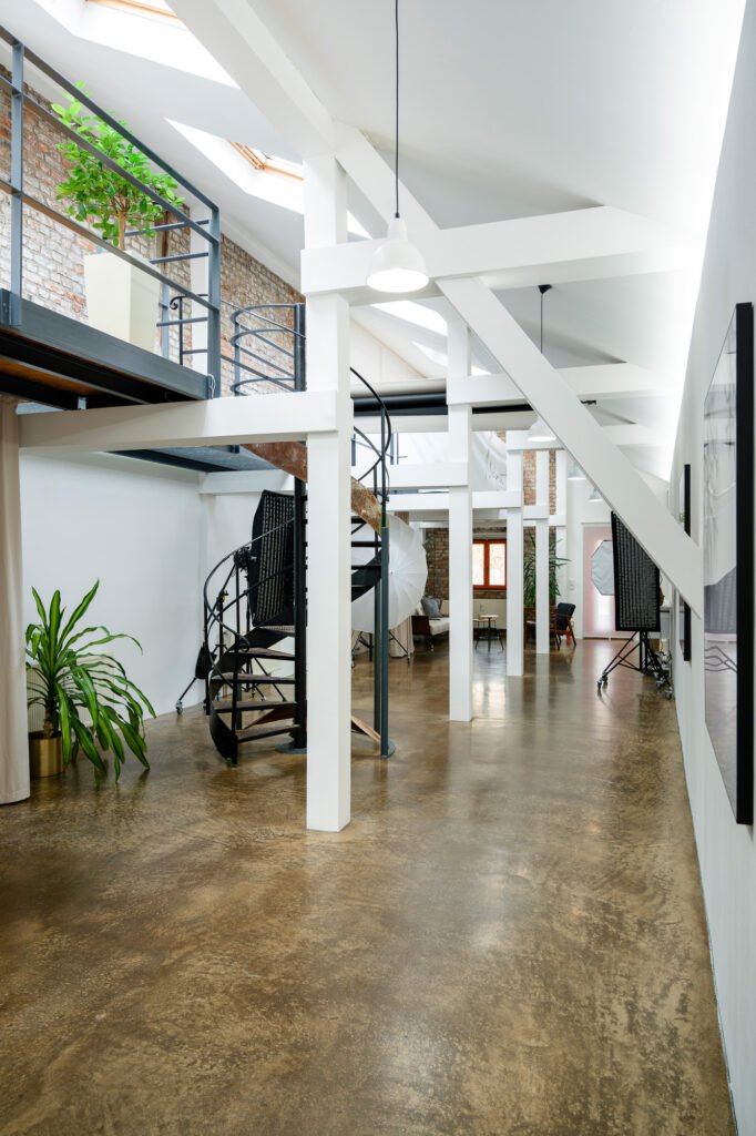 Helles, industrielles Büroloft mit Pflanzen und Spiraltreppe als urbaner Arbeitsplatz für Agenturen in Köln Ehrenfeld.