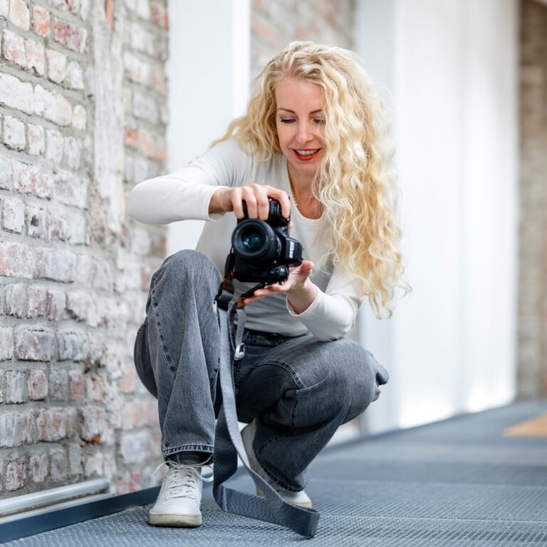 Businessfotografin Karin Maigut beim Fotografieren im Studio Köln Ehrenfeld mit Blick auf die Kamera für Ziegelwand